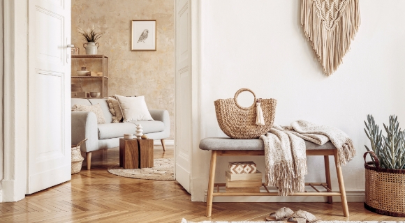 Heller Boho-Flur mit Makramee, Bank, Korbtasche und Blick auf ein gemütliches Wohnzimmer mit Naturtönen und Texturen