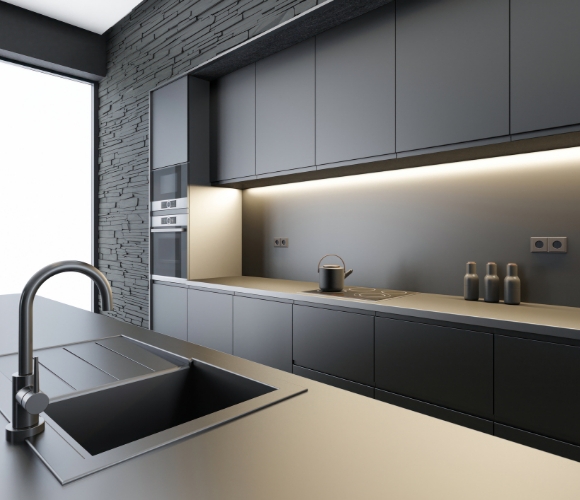 Minimalistische K&uuml;che mit dunklen Fronten, Steinwand und beleuchteter Arbeitsfl&auml;che