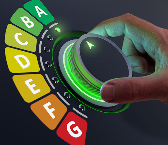 Hand dreht einen Energiewahlregler von G bis A auf grün markierte Energieeffizienzstufe.