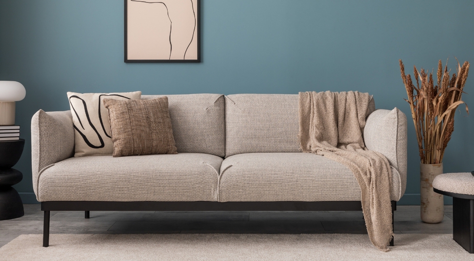 Beiges Sofa vor blauer Wand