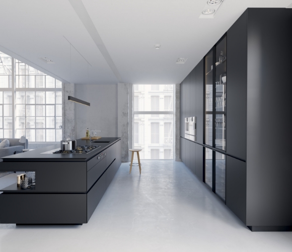 Geradlinige Designk&uuml;che in Mattschwarz mit langer Arbeitsinsel, dunkler Schrankwand, Industriecharakter in hellem Wohnbereich
