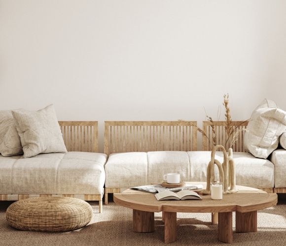 Minimalistisch eingerichtetes Wohnzimmer mit naturfarbenem Sofa und runden Rattan-Elementen.