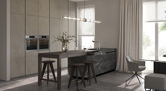 Elegante, moderne Büroküche mit hochwertigen Materialien in Schwarz, Weiß und Naturtönen. Die Küchenzeile besteht aus hochglänzenden, schwarz-gemusterten Marmorfronten mit integrierter Spüle und dunkler Arbeitsplatte. Davor steht ein hoher, dunkler Bartisch mit zwei passenden Hockern. Links an der Wand befinden sich deckenhohe Einbauschränke in hellgrauer Betonoptik mit zwei integrierten Edelstahl-Backöfen. Eine lineare Pendelleuchte mit Glaszylindern beleuchtet den Essbereich. Helle Vorhänge und zwei große Fenster lassen viel Tageslicht in den Raum. Rechts stehen gepolsterte Bürostühle und ein Tisch, was die Küche als Teil eines offenen, kommunikativen Bürobereichs erkennen lässt. Die Atmosphäre wirkt modern, stilvoll und funktional.