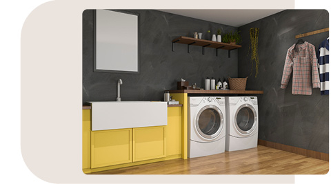 Moderner Hauswirtschaftsraum mit gelben Schränken, weißem Waschtrog, Waschmaschine und Trockner unter Holzplatte, dunkler Wand, Holzregal und Kleidung an der Wand.