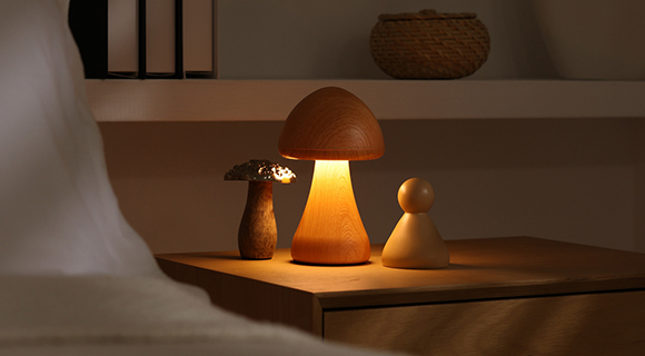 Warm beleuchtete Nachttischszene mit moderner Pilzlampe, Dekoration und Büchern im minimalistischen Stil.