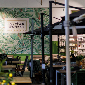 Gartenm&ouml;belausstellung mit gro&szlig;em Plakat von Sch&ouml;ner Wohnen