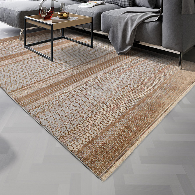 Gro&szlig;er, rechteckiger Teppich in Braun und Beige mit gewebtem Rautenmuster und dekorativen Streifen. Der Teppich liegt vor einem grauen Sofa auf hellem Fischgr&auml;tboden. Auf dem Teppich steht ein moderner Couchtisch mit schwarzem Metallgestell und Holzplatte, darauf Gl&auml;ser, ein Buch und eine Schale.