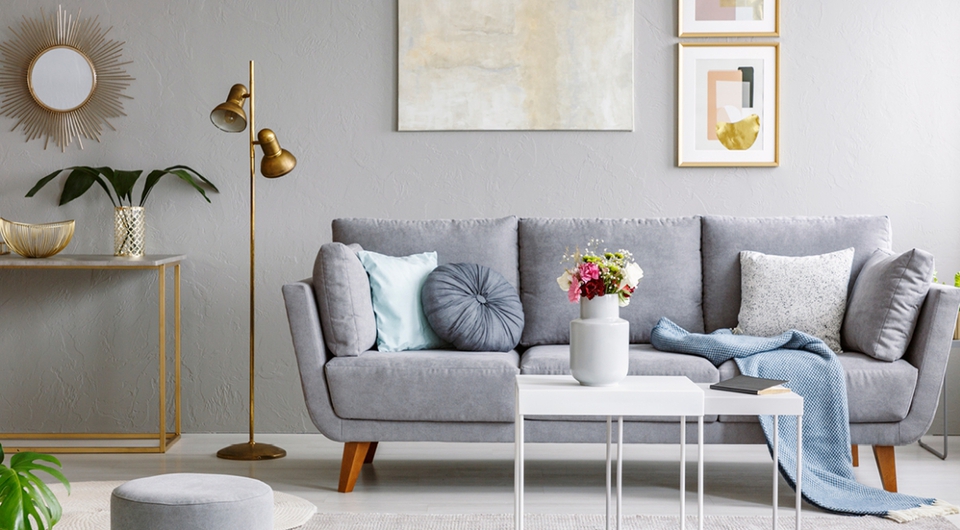 Modernes Wohnzimmer mit grauem Sofa und 2 weißen Couchtischen