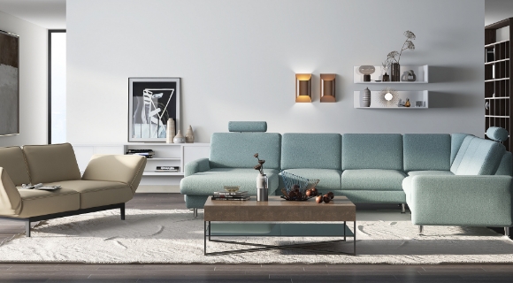 Helles Wohnzimmer mit blauem und beigem Sofa, in der Mitte ein eckiger Couchtisch