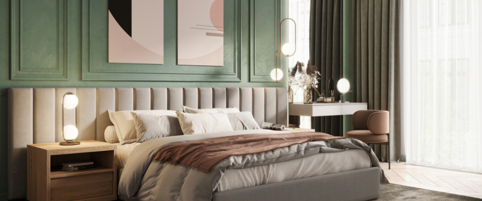 Graues Boxspringbett steht vor einer grünen Wand in einem modern eingerichteten Schlafzimmer. 