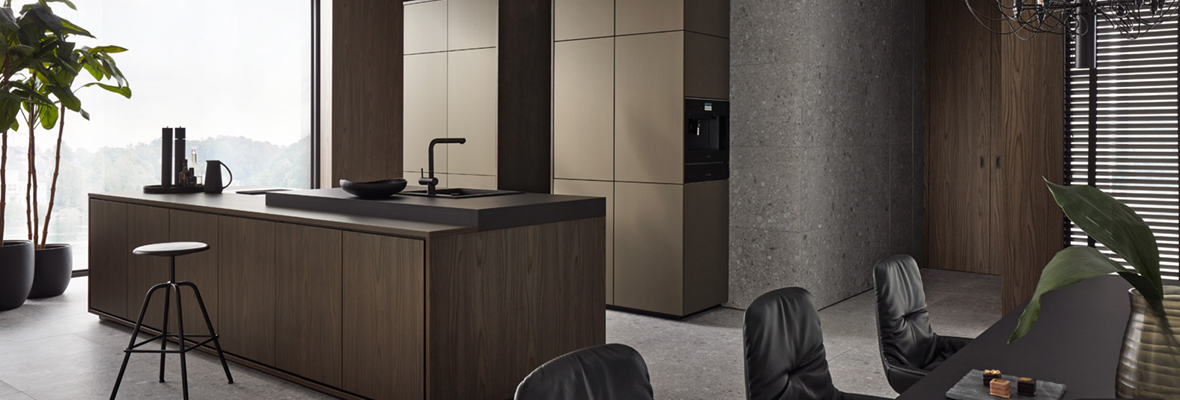 Minimalistische Küche in dunklem Holz und Grau mit modernem Design. Die Küche verfügt über eine zentrale Insel mit schwarzer Arbeitsfläche und eine schlichte Wandgestaltung. Der Essbereich ist mit schwarzen Stühlen und einer großen Pflanze dekoriert, die Fenster sind mit Lamellenjalousien versehen