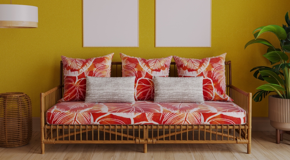 Rot-buntes Schlafsofa vor einer gelben Wand