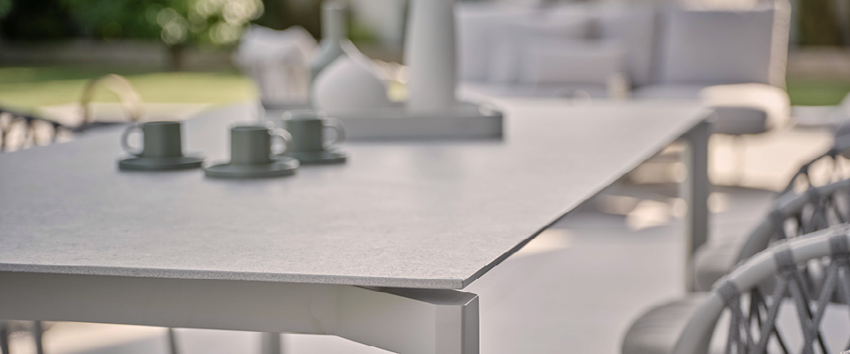 Esstisch mit Keramikplatte mit St&uuml;hlen und Deko auf einer terasse im garten