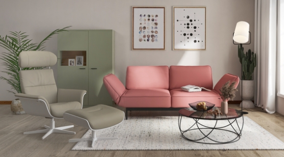 Helles Wohnzimmer mit Rosa Couch, grünem Sessel und rundem Couchtisch
