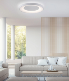 Helles, monochrom gehaltenes Wohnzimmer mit beigen Sofas, runden Couchtischen und moderner Deckenleuchte.