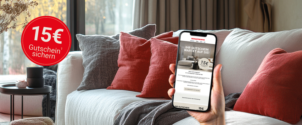 Frau nutzt Smartphone-Gutschein mit 15 € Rabattangebot auf einer Couch