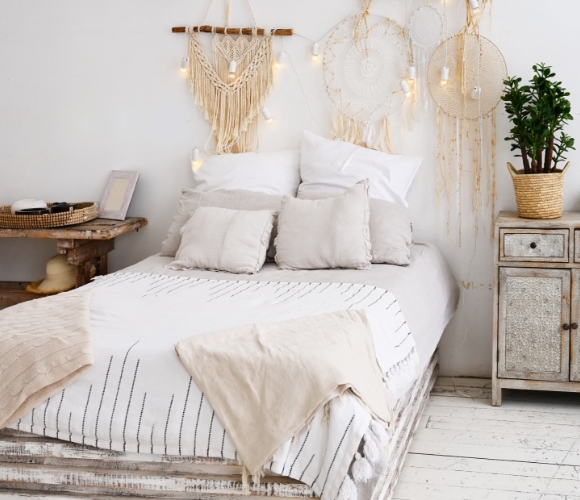 Boho-Schlafzimmer mit Palettenbett, Leinenbettwäsche, Traumfängern und Holzdetails