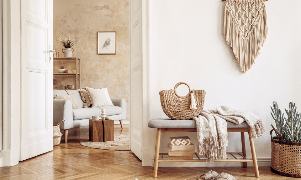 Heller Boho-Flur mit Makramee, Bank, Korbtasche und Blick auf ein gemütliches Wohnzimmer mit Naturtönen und Texturen