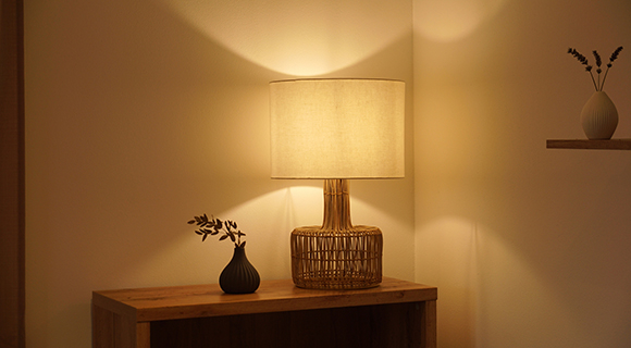 Moderne Boho Holz-Tischlampe auf einer Kommode neben einer Vase im modernen Wohnzimmer. 