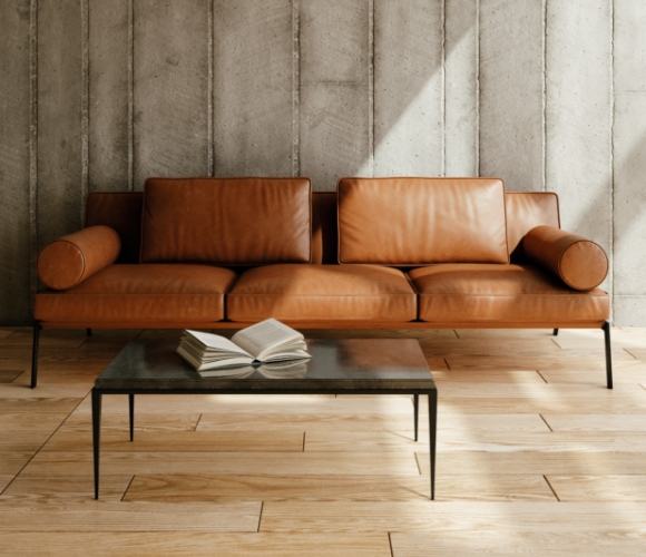 Wohnzimmer im Industrial Look mit Leder-Sofa, Betonstruktur und minimalistischer Einrichtung