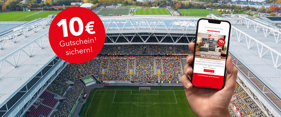 Hand h&auml;lt Smartphone-Gutschein mit 10 &euro; Rabattangebot vor einem Fu&szlig;ball-Stadion
