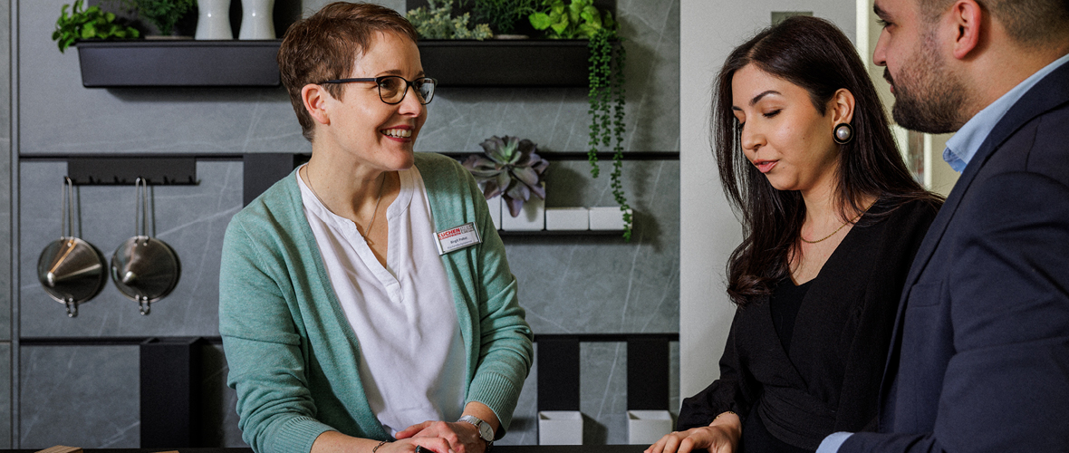 Eine Mitarbeiterin beraet Kunden zuhause und plant mit ihnen ihre individuelle Kueche