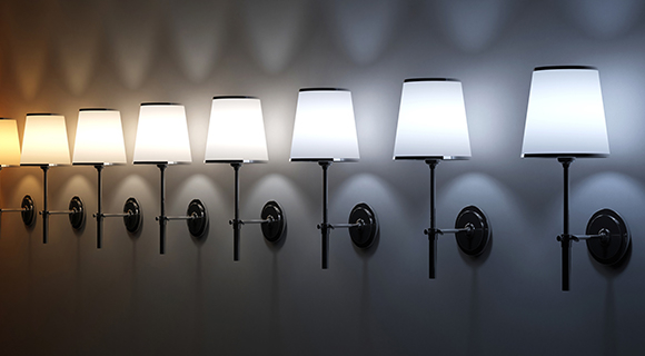 Wandleuchten in einer Reihe zeigen unterschiedliche Lichtfarben von warmweiß bis tageslichtweiß als Vergleich der Farbtemperaturen. 