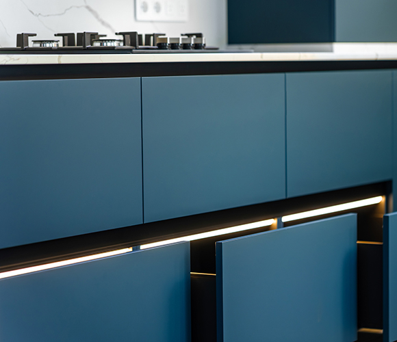 Moderne Küche mit mattblauen Schubladenfronten und integrierter LED-Beleuchtung.