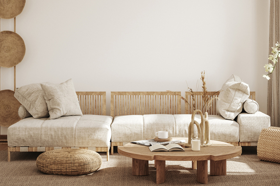 Minimalistisch eingerichtetes Wohnzimmer mit naturfarbenem Sofa und runden Rattan-Elementen.