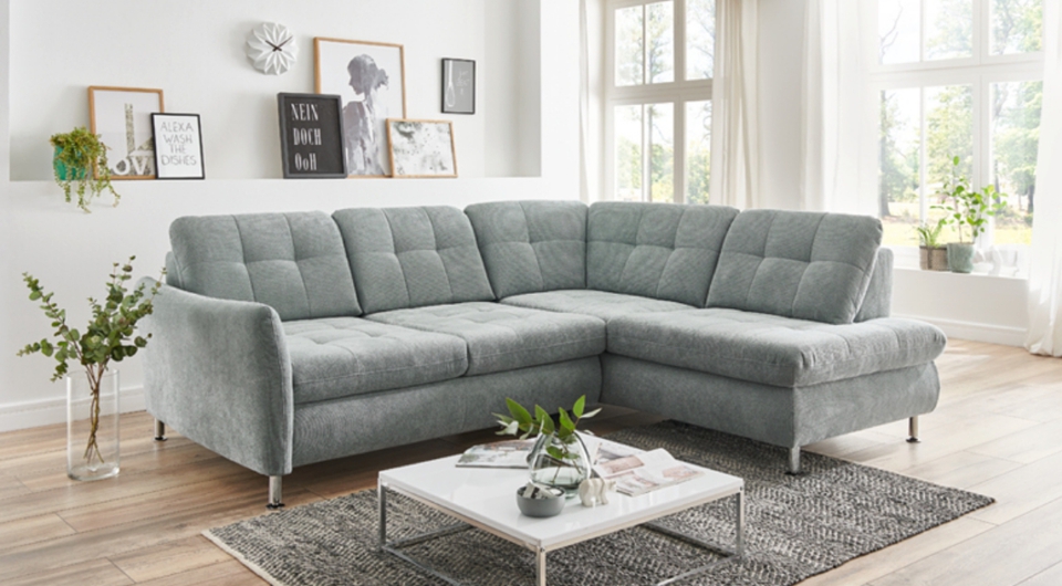 graues Sofa in L-Form in einem hellen Wohnzimmer