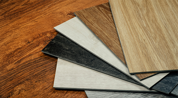Tischplatte aus Holz, auf der verschiedene Materialmuster-Beispiele liegen.