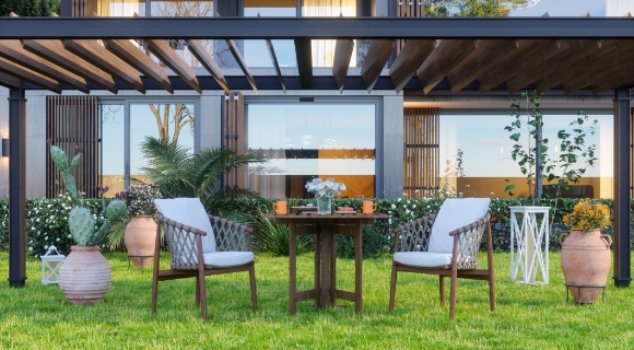 Zwei Outdoor Loungesesseln aus Holz stehen zusammen mit einem Tisch unter einer &Uuml;berdachung.