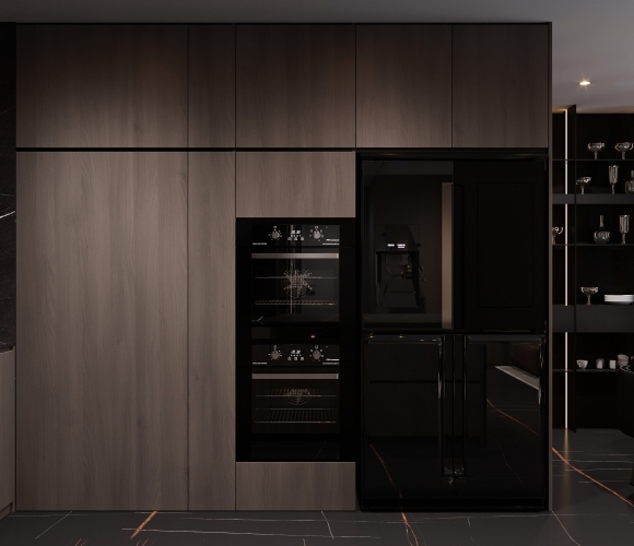 Moderner Hochschrank-Block mit integriertem Backofen, Kaffeevollautomat und gro&szlig;em K&uuml;hlschrank in dunklem Holzdesign