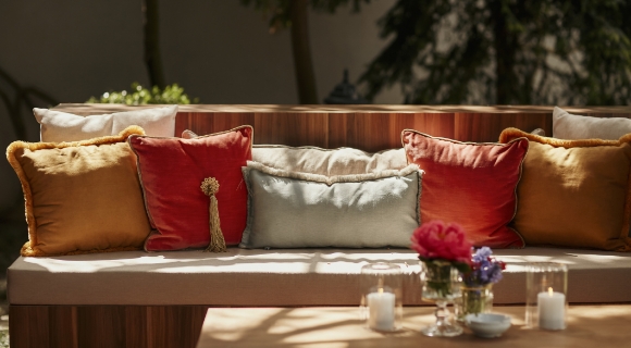 Erdfarbenen Kissen auf einem h&ouml;lzernen Outdoor Sofa.