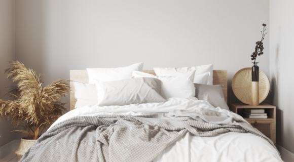 Skandinavisches Schlafzimmer mit Deko-Elementen neben dem Bett.