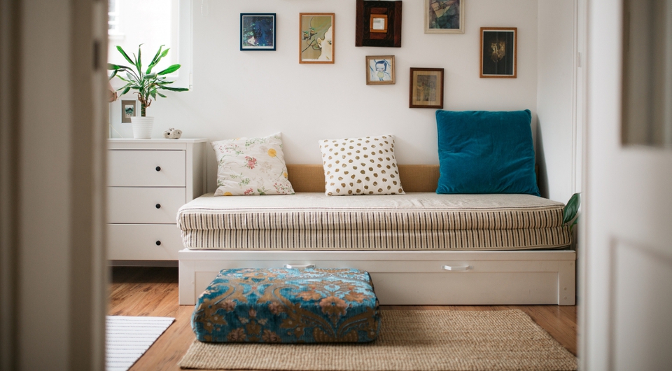 Kinderzimmer mit Kommode. Bildern an der Wand und einem Schlafsofa
