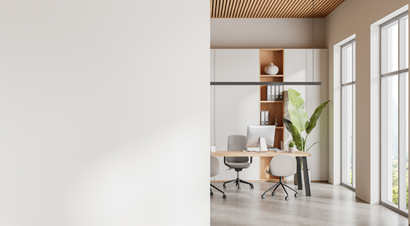 Helles Büro mit zwei modernen Schreibtischen und Bürostühlen vor großen Fenstern.