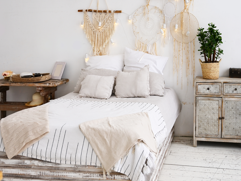 Boho-Schlafzimmer mit Palettenbett, Leinenbettwäsche, Traumfängern und Holzdetails
