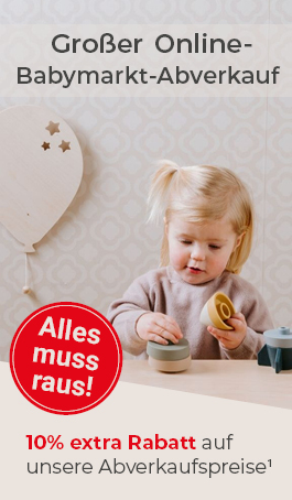 Kleinkind sitzt an einem Tisch und spielt mit Kinderspielzeug